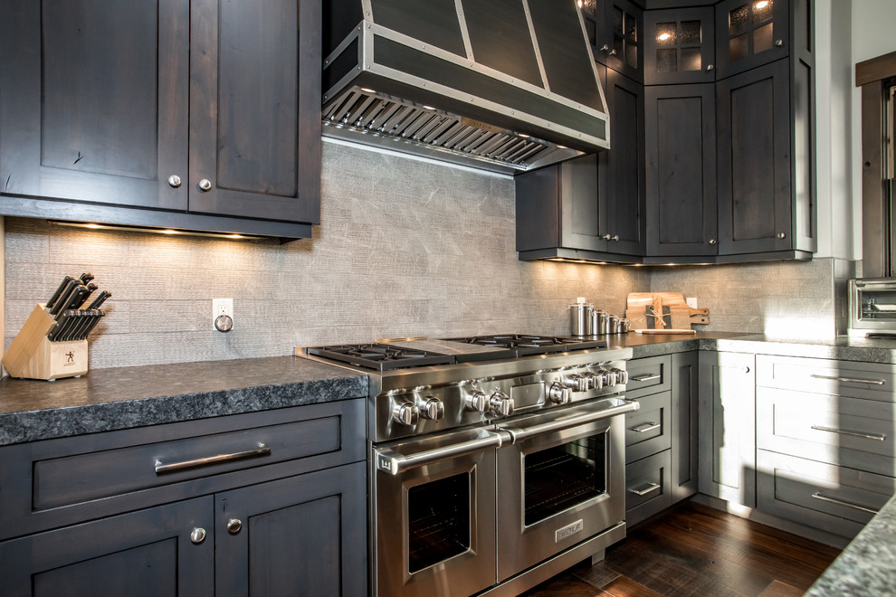 Example of a large transitional u-shaped dark wood floor and brown floor open concept kitchen design with an undermount sink, shaker cabinets, dark wood cabinets, granite countertops, gray backsplash, stone tile backsplash, paneled appliances, an island and gray countertops