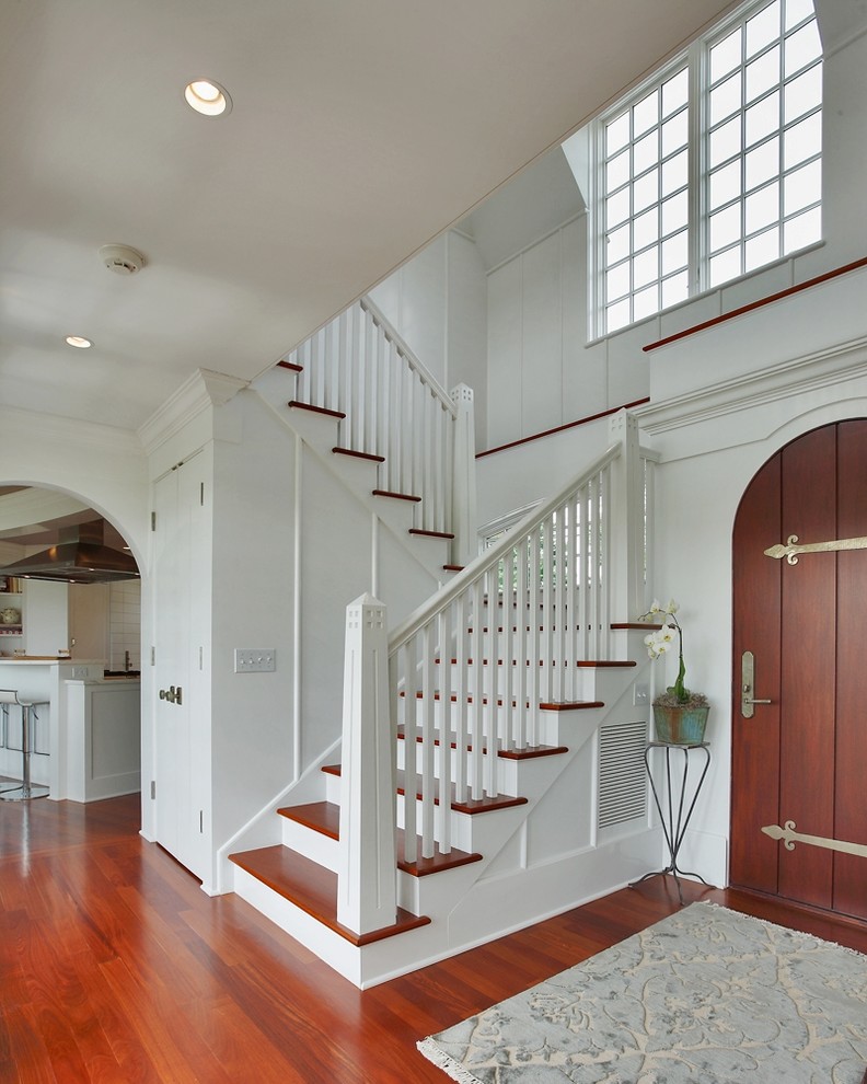 Photo of a mid-sized beach style foyer in New York with white walls, medium hardwood floors, a single front door, a dark wood front door and red floor.