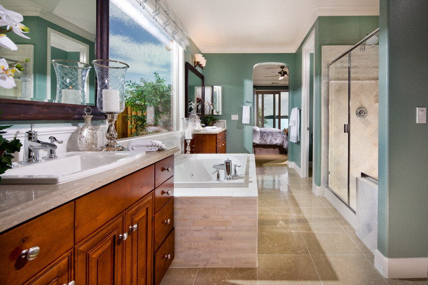 Large transitional master bathroom in San Francisco with raised-panel cabinets, medium wood cabinets, a drop-in tub, an alcove shower, blue walls, a drop-in sink, a hinged shower door, limestone benchtops and beige floor.