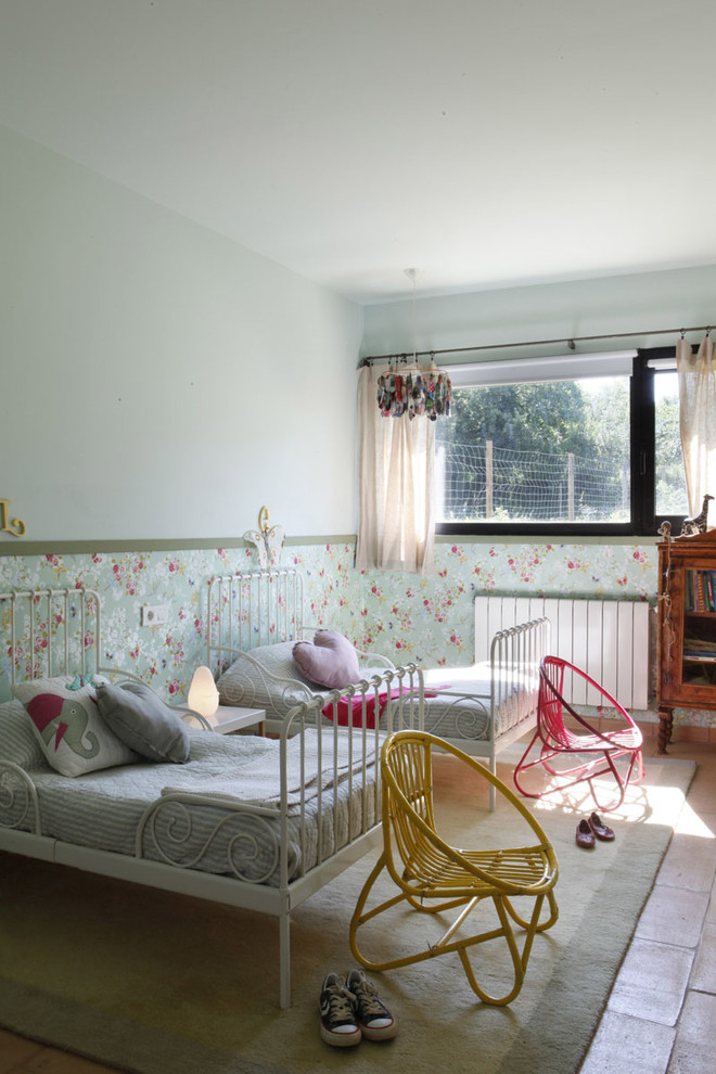 Photo of a mid-sized country kids' bedroom for kids 4-10 years old and girls in Barcelona with blue walls and terra-cotta floors.