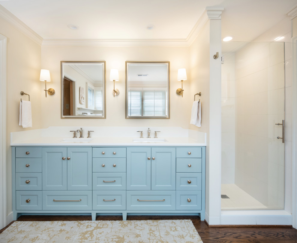 Inspiration for a traditional master bathroom in Kansas City with shaker cabinets, blue cabinets, an alcove shower, white tile, porcelain tile, dark hardwood floors, an undermount sink, engineered quartz benchtops, a hinged shower door, white benchtops, a double vanity and a built-in vanity.