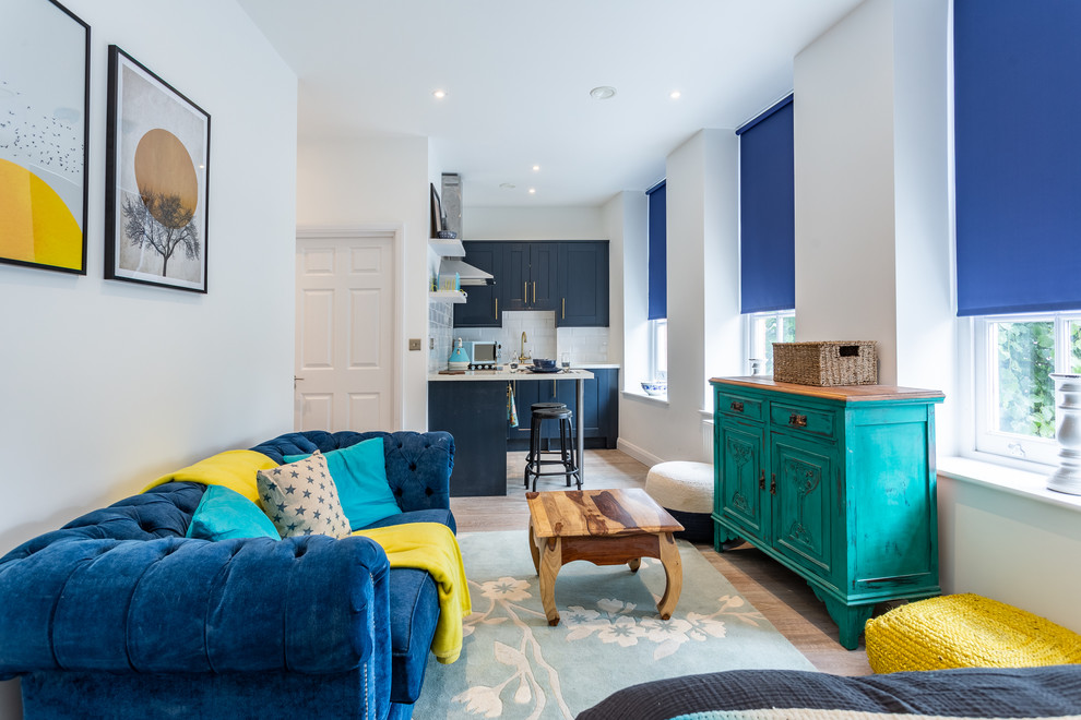 Example of a small trendy open concept light wood floor living room design in London with white walls, no tv and no fireplace