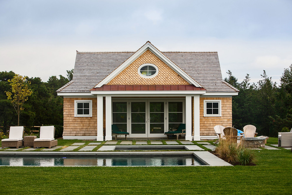 Example of a large transitional backyard stone and rectangular natural pool house design in Boston