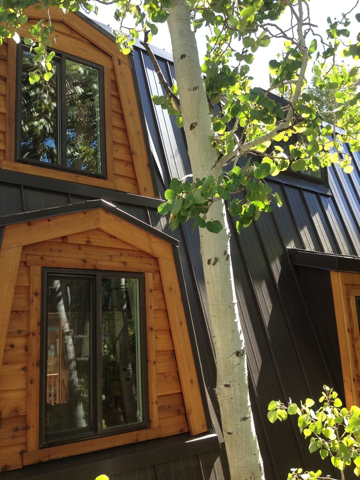 Example of a large mountain style brown two-story wood house exterior design with a metal roof