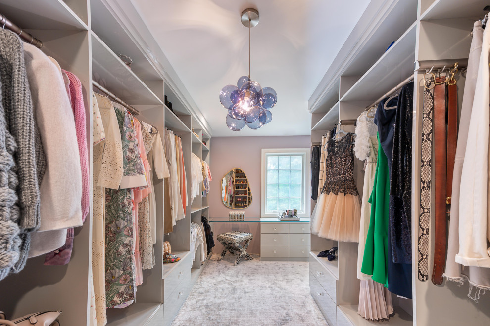 Inspiration for a transitional women's dressing room in New York with flat-panel cabinets, grey cabinets, carpet and grey floor.