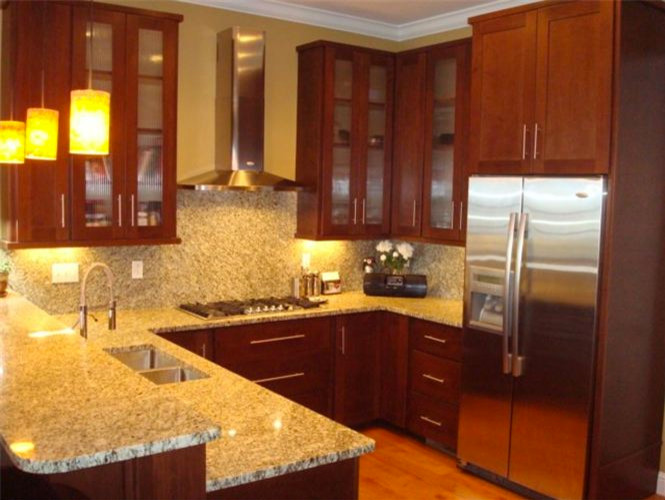 Inspiration for a small u-shaped light wood floor eat-in kitchen remodel with a double-bowl sink, medium tone wood cabinets, granite countertops and stainless steel appliances