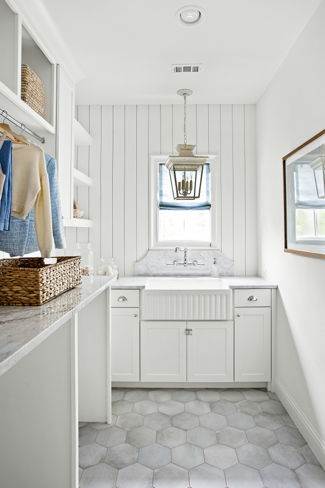 Design ideas for an expansive transitional dedicated laundry room in Dallas with a farmhouse sink, shaker cabinets, white splashback, shiplap splashback, white walls, a side-by-side washer and dryer, grey floor and grey benchtop.