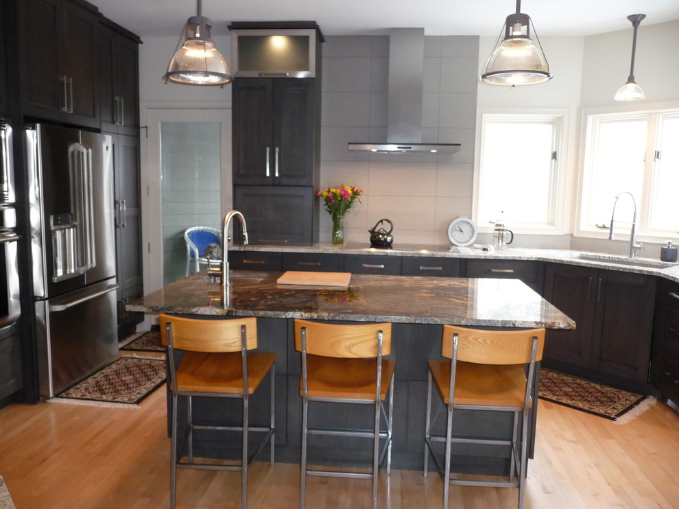 Large transitional u-shaped light wood floor eat-in kitchen photo in Milwaukee with an undermount sink, flat-panel cabinets, gray cabinets, granite countertops, white backsplash, porcelain backsplash, stainless steel appliances and an island