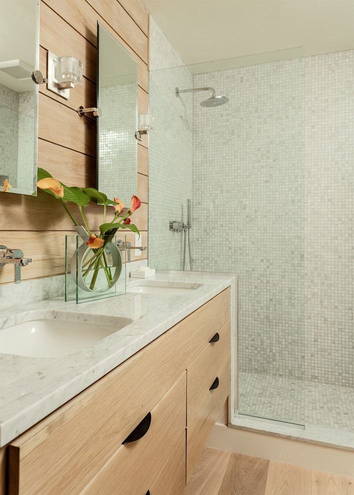 Photo of a contemporary master bathroom in Boston with light wood cabinets, beige walls, an open shower, flat-panel cabinets, mosaic tile, light hardwood floors, an undermount sink, beige floor, a corner shower, blue tile, grey benchtops, a double vanity, a floating vanity and wood walls.