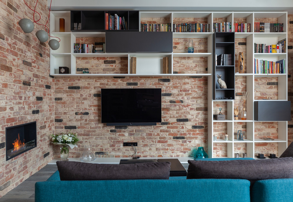Design ideas for an industrial living room in Moscow with a library, a ribbon fireplace and a wall-mounted tv.