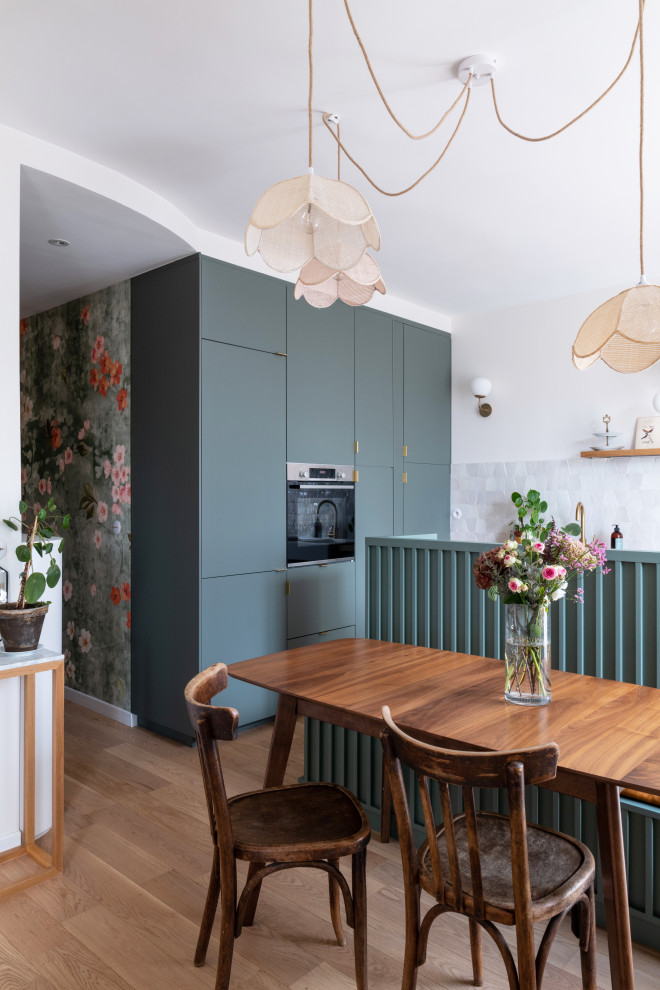 Inspiration for a small l-shaped open plan kitchen in Paris with a drop-in sink, beaded inset cabinets, green cabinets, wood benchtops, beige splashback, terra-cotta splashback, panelled appliances, light hardwood floors, with island, brown floor and brown benchtop.