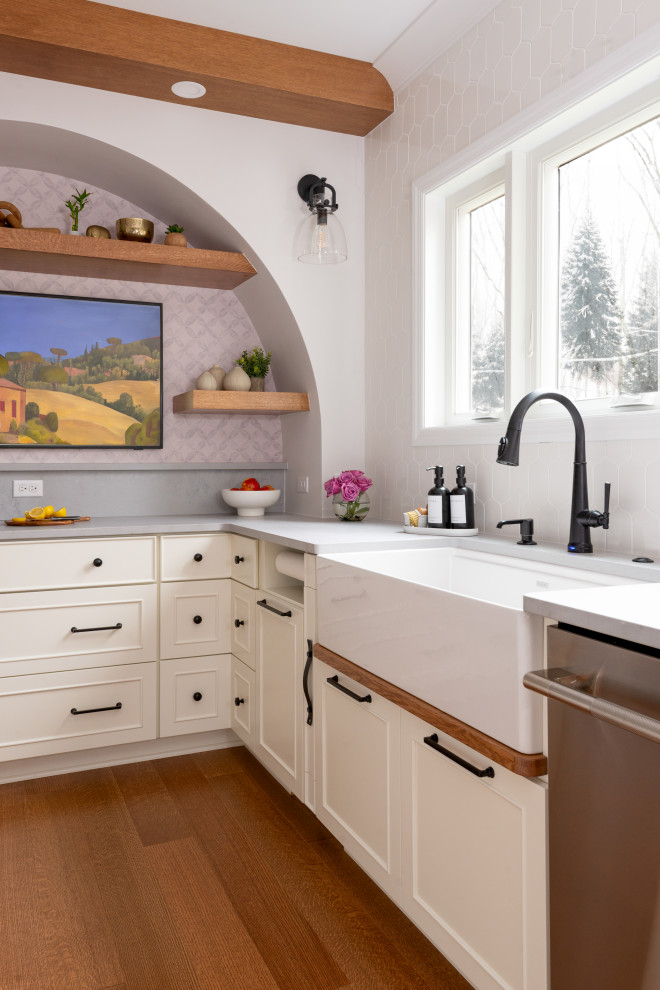Eat-in kitchen - large medium tone wood floor and exposed beam eat-in kitchen idea with white backsplash, stainless steel appliances and an island