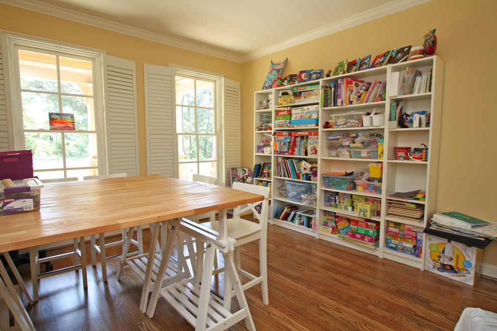 Inspiration for a mid-sized traditional gender-neutral kids' playroom for kids 4-10 years old in Atlanta with yellow walls, medium hardwood floors and brown floor.