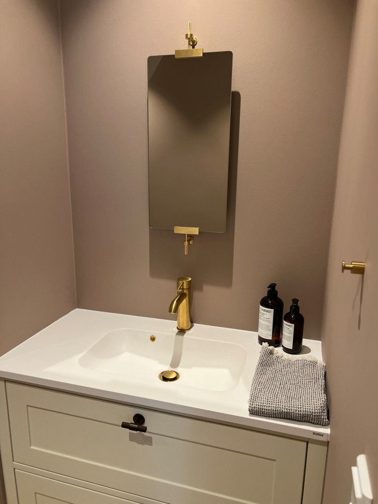 Idées déco pour un petit WC suspendu classique avec un placard en trompe-l'oeil, des portes de placard beiges, un mur rose, parquet clair, un lavabo intégré, un plan de toilette en quartz, un sol multicolore, un plan de toilette blanc, meuble-lavabo suspendu et du papier peint.