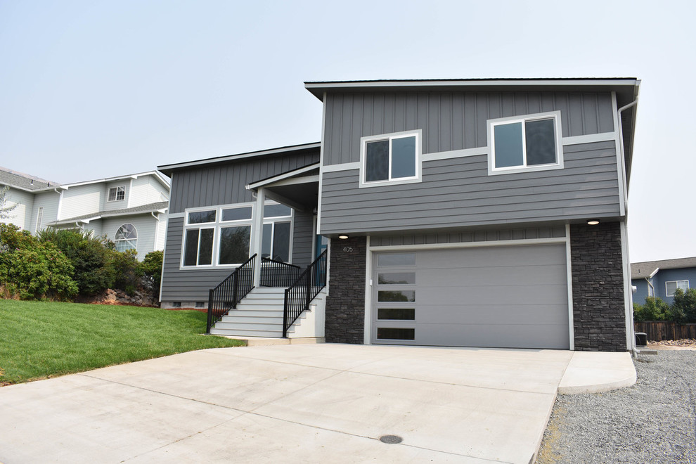 This is an example of a mid-sized transitional two-storey grey house exterior in Other with vinyl siding, a flat roof and a green roof.