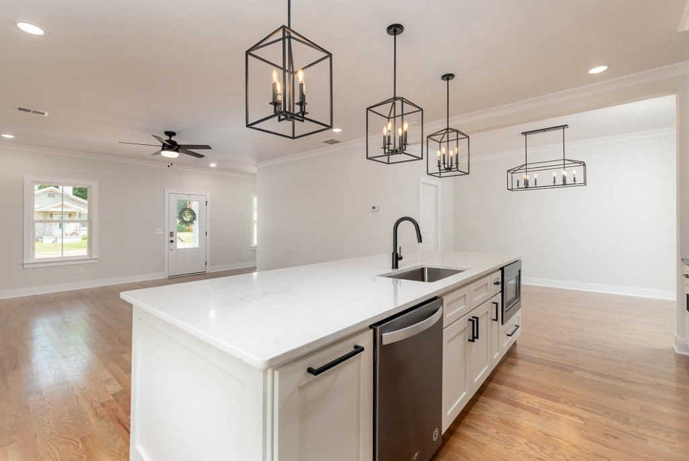 Example of a large transitional galley medium tone wood floor and brown floor open concept kitchen design with an undermount sink, shaker cabinets, white cabinets, quartz countertops, white backsplash, ceramic backsplash, stainless steel appliances, an island and white countertops