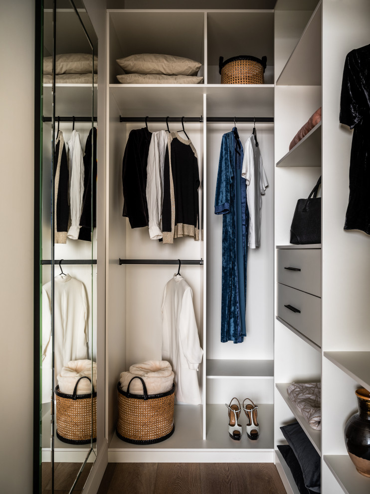 Example of a small trendy gender-neutral vinyl floor and beige floor walk-in closet design in Moscow with flat-panel cabinets and white cabinets