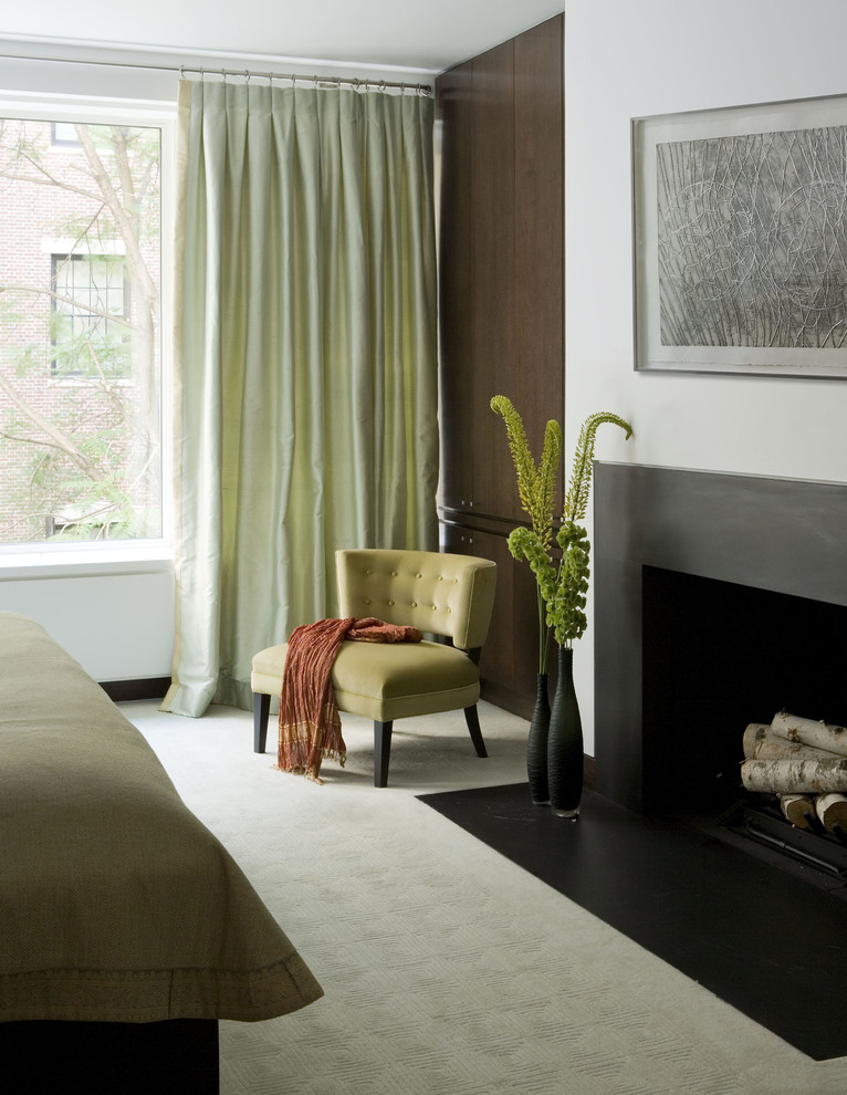 Photo of a mid-sized transitional master bedroom in New York with white walls, carpet, a standard fireplace and a metal fireplace surround.