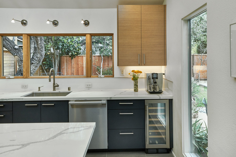 Design ideas for a mid-sized contemporary u-shaped separate kitchen in San Francisco with an undermount sink, flat-panel cabinets, light wood cabinets, marble benchtops, white splashback, glass sheet splashback, stainless steel appliances, slate floors, with island, grey floor and white benchtop.