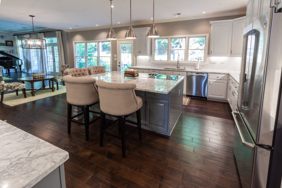 Eat-in kitchen - mid-sized transitional l-shaped dark wood floor and brown floor eat-in kitchen idea with an undermount sink, raised-panel cabinets, white cabinets, granite countertops, white backsplash, ceramic backsplash, stainless steel appliances and an island