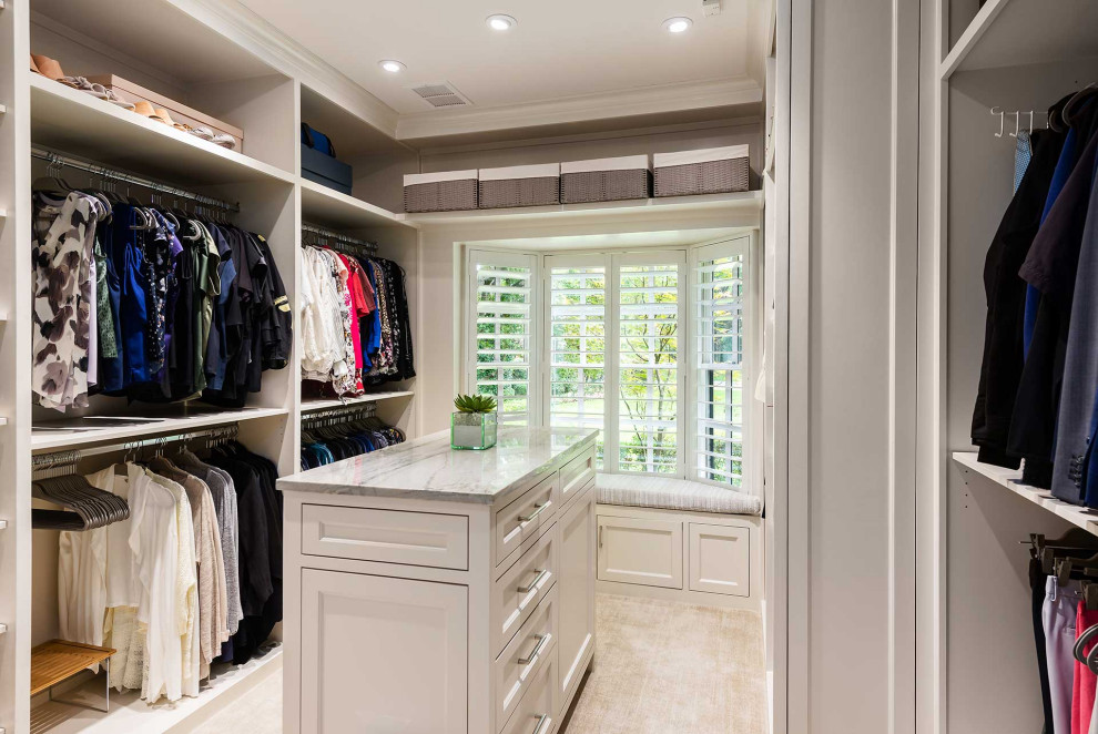 Large modern gender-neutral dressing room in Dallas with shaker cabinets, white cabinets, carpet and beige floor.