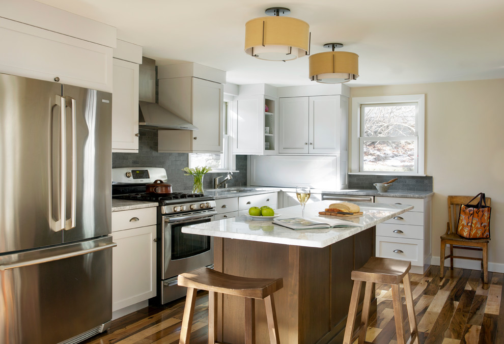 Inspiration for a traditional l-shaped kitchen in Boston with an undermount sink, shaker cabinets, white cabinets, grey splashback, white appliances, medium hardwood floors and with island.
