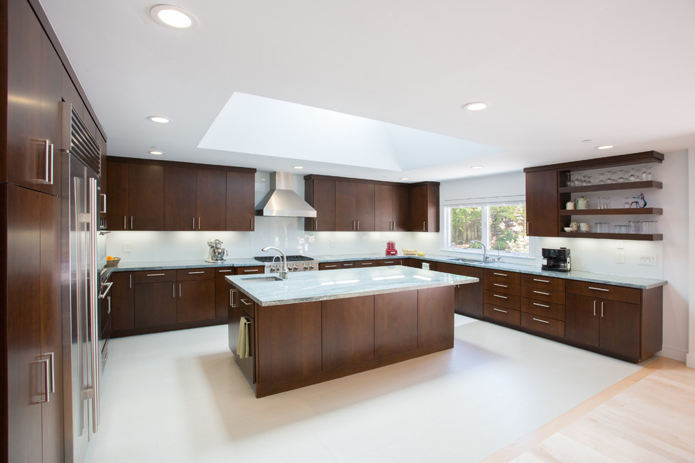 Photo of a contemporary u-shaped kitchen in San Francisco with an undermount sink, flat-panel cabinets, dark wood cabinets, white splashback, glass sheet splashback and stainless steel appliances.