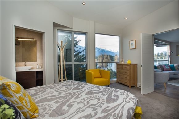This is an example of a mid-sized contemporary master bedroom in Other with beige walls, carpet and grey floor.