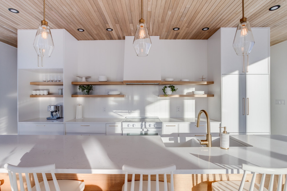 モントリオールにある北欧スタイルのおしゃれなキッチン (アンダーカウンターシンク、フラットパネル扉のキャビネット、白いキャビネット、白いキッチンパネル、塗装板のキッチンパネル、コンクリートの床、板張り天井) の写真