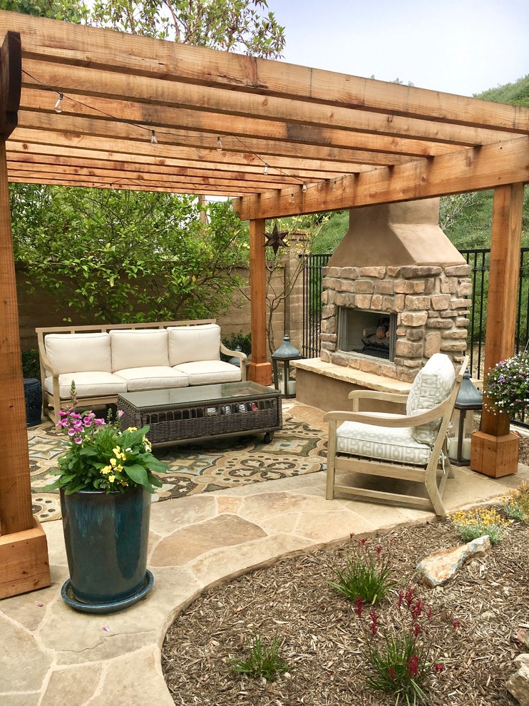 Inspiration for a small craftsman courtyard stone patio remodel in Orange County with a fire pit and a pergola