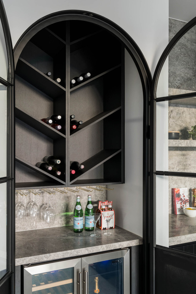 Photo of a small contemporary wine cellar in Melbourne with concrete floors, display racks and grey floor.