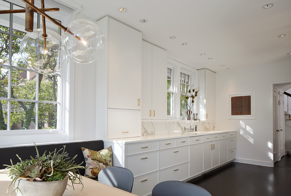 Inspiration for a traditional galley kitchen in Chicago with an integrated sink, recessed-panel cabinets, white cabinets, solid surface benchtops, marble splashback and dark hardwood floors.