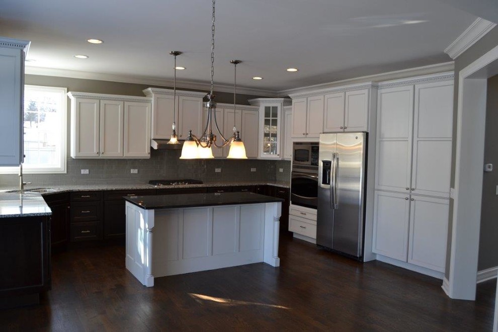 Example of a large transitional u-shaped dark wood floor and brown floor enclosed kitchen design in Chicago with a double-bowl sink, shaker cabinets, white cabinets, stainless steel appliances, an island, gray backsplash and subway tile backsplash