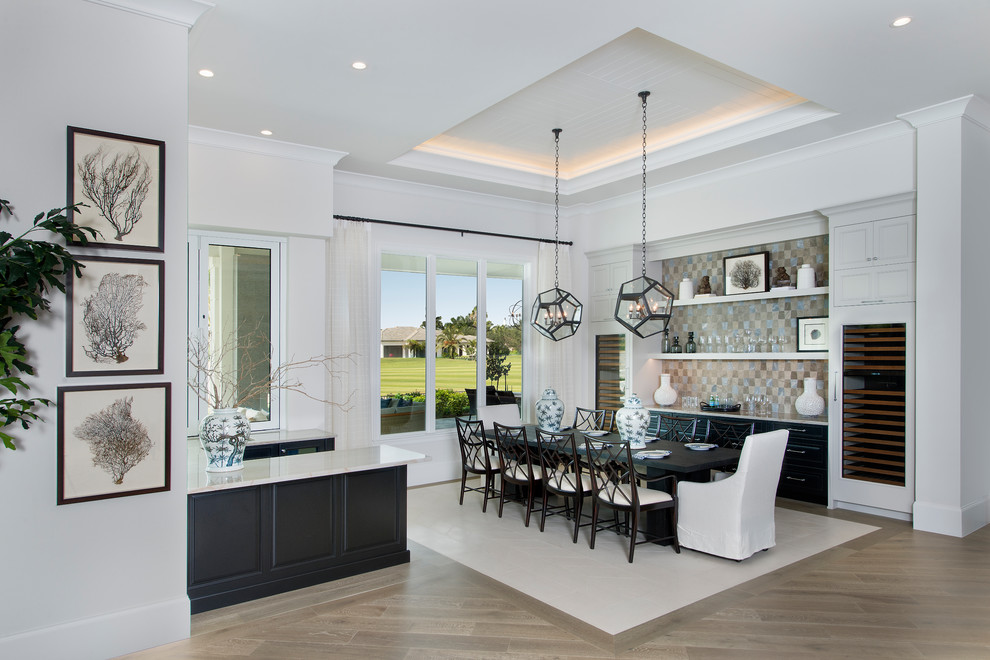 Photo of a mid-sized transitional open plan dining in Miami with white walls, light hardwood floors and no fireplace.