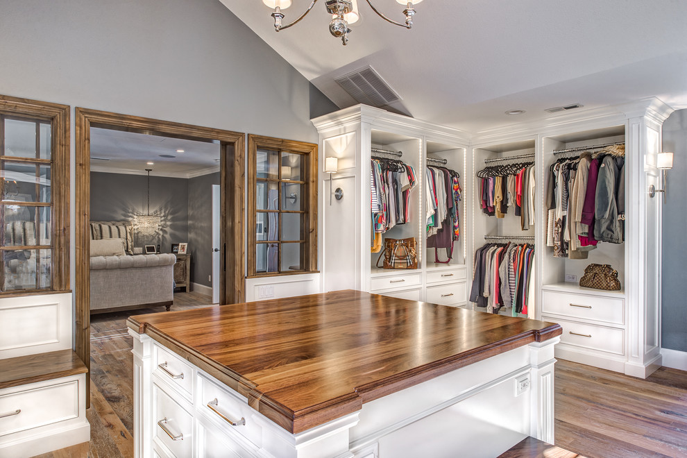 Design ideas for an expansive traditional gender-neutral dressing room in Denver with beaded inset cabinets, white cabinets and light hardwood floors.