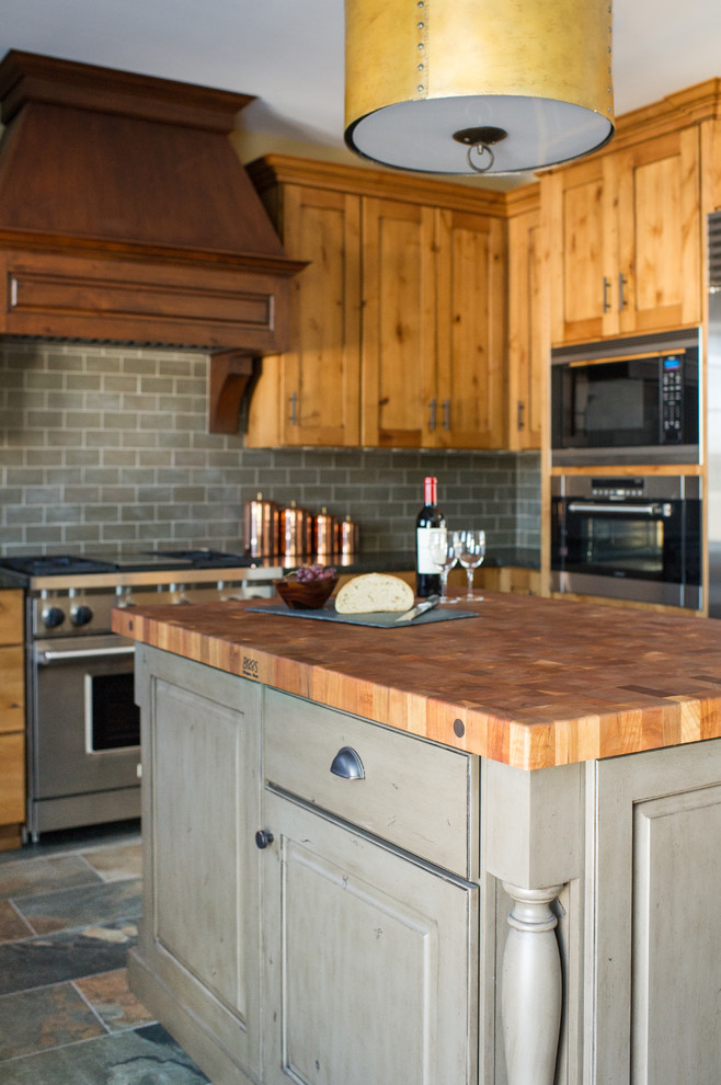 Inspiration for a mid-sized rustic u-shaped porcelain tile eat-in kitchen remodel in Chicago with an undermount sink, shaker cabinets, distressed cabinets, granite countertops, gray backsplash, ceramic backsplash and stainless steel appliances