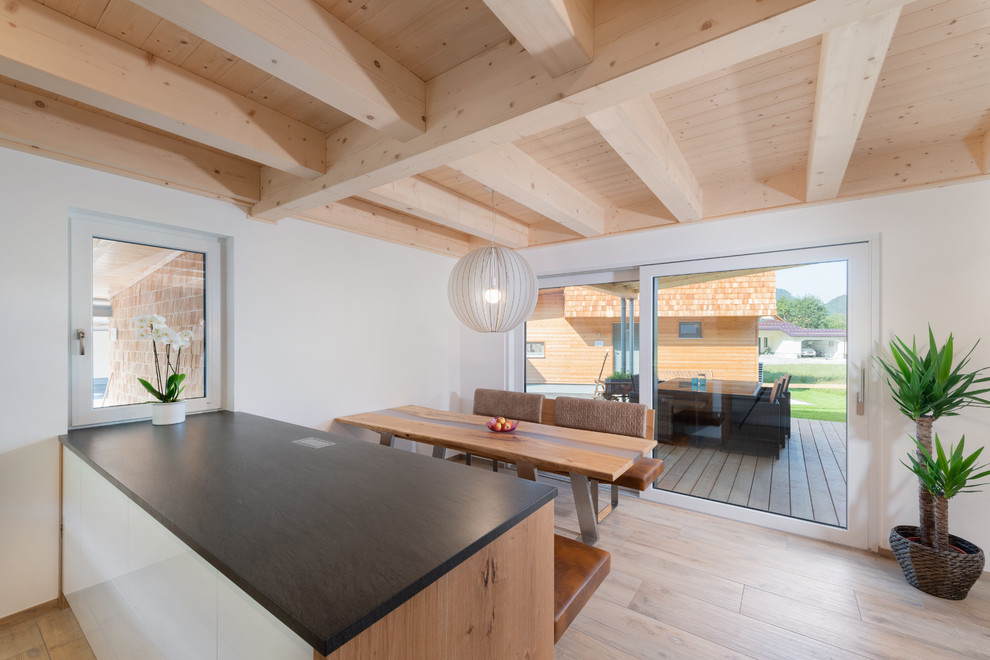 Große Moderne Wohnküche mit weißer Wandfarbe, hellem Holzboden und beigem Boden in Nürnberg
