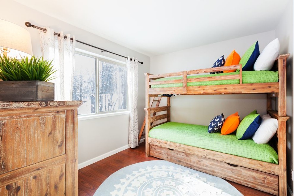 This is an example of a small country gender-neutral kids' bedroom for kids 4-10 years old in Other with grey walls, medium hardwood floors and brown floor.