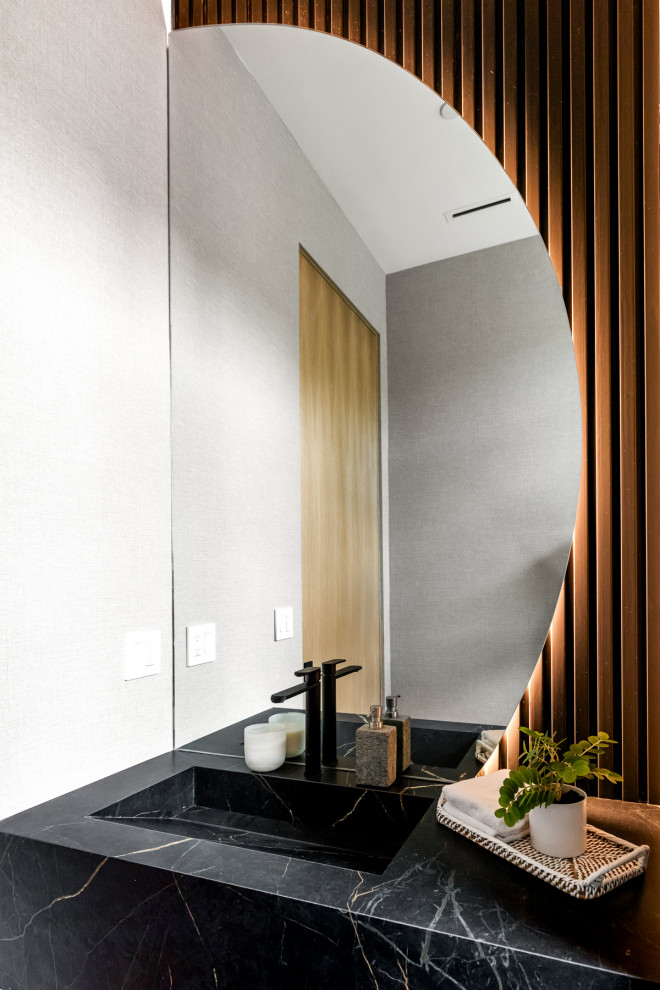 Inspiration pour un WC et toilettes design avec un plan de toilette en marbre, meuble-lavabo encastré et du lambris.