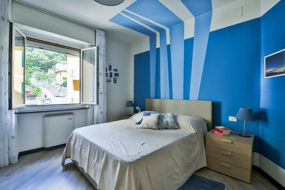 Modernes Hauptschlafzimmer mit blauer Wandfarbe, Laminat, beigem Boden und Wandgestaltungen in Sonstige