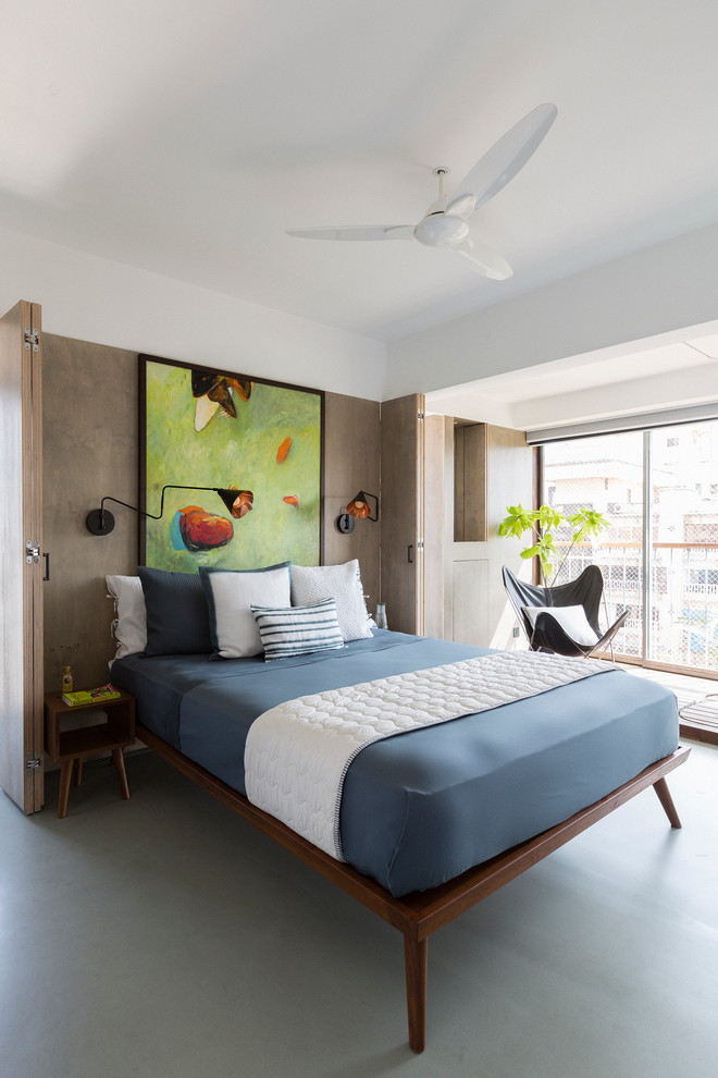 Design ideas for a small contemporary master bedroom in Pune with grey walls and concrete floors.