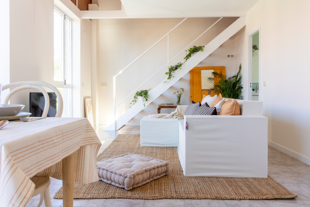 Стильный дизайн: открытая гостиная комната среднего размера, в белых тонах с отделкой деревом в стиле фьюжн с белыми стенами, полом из керамической плитки, отдельно стоящим телевизором и серым полом - последний тренд
