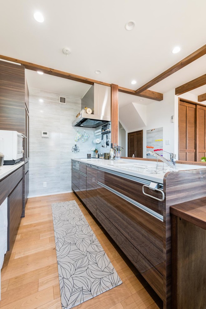 Asian galley open plan kitchen in Other with an integrated sink, flat-panel cabinets, dark wood cabinets, medium hardwood floors, a peninsula and brown floor.