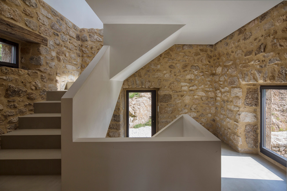 This is an example of a mid-sized mediterranean concrete u-shaped staircase in Stuttgart with concrete risers.