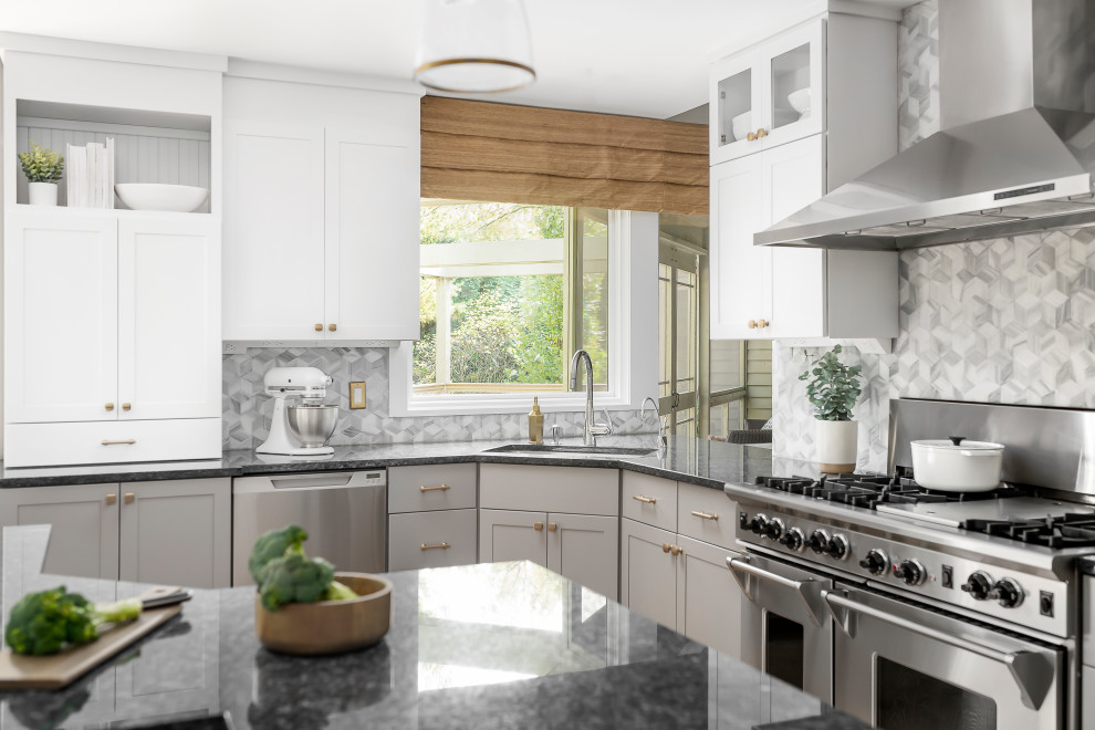 Inspiration for a large transitional medium tone wood floor open concept kitchen remodel in Chicago with an undermount sink, shaker cabinets, white cabinets, granite countertops, gray backsplash, marble backsplash, stainless steel appliances, an island and black countertops
