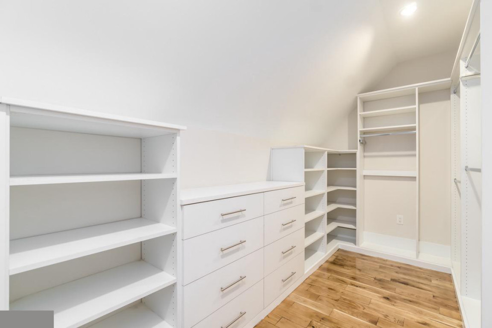 This is an example of a contemporary gender neutral built-in wardrobe in DC Metro with light hardwood flooring and brown floors.