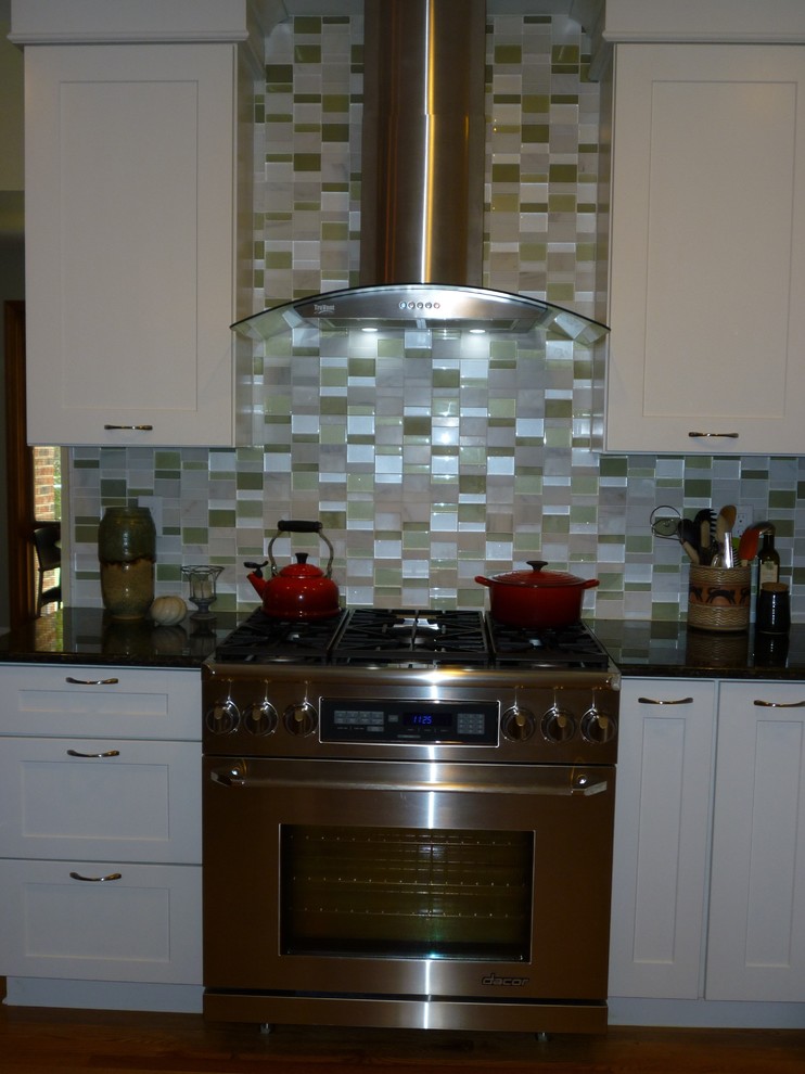 Inspiration for a mid-sized transitional galley concrete floor open concept kitchen remodel in St Louis with a farmhouse sink, shaker cabinets, medium tone wood cabinets, granite countertops, white backsplash, ceramic backsplash, stainless steel appliances and an island