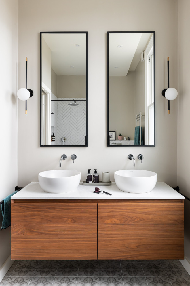 Large trendy master white tile and porcelain tile dark wood floor, brown floor, double-sink and coffered ceiling bathroom photo in London with flat-panel cabinets, brown cabinets, a wall-mount toilet, beige walls, a console sink, limestone countertops, beige countertops, a niche and a floating vanity