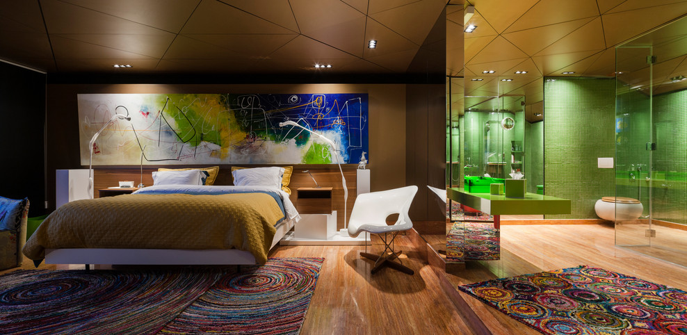 Large contemporary master bedroom in Barcelona with medium hardwood floors, brown floor and brown walls.