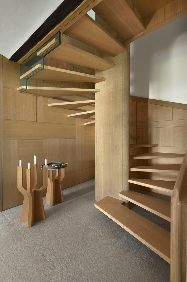 Large contemporary wood spiral staircase in Paris with open risers.